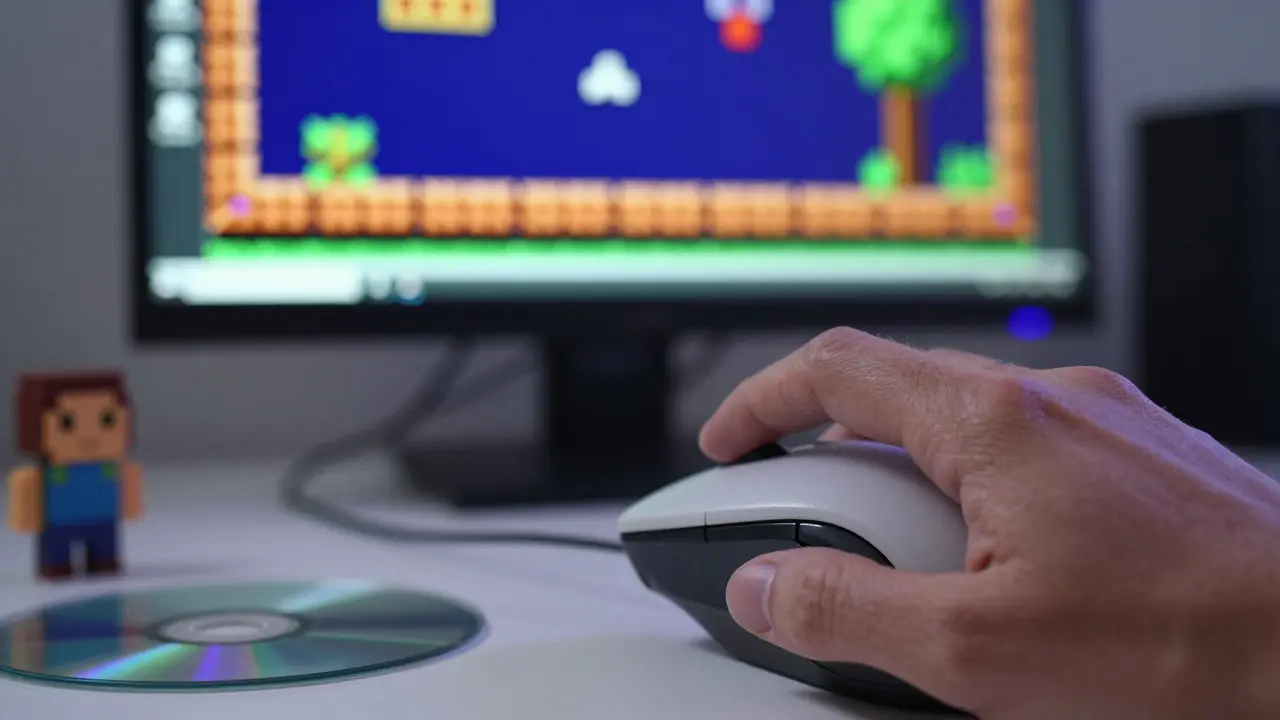 Hand clicking old mouse while playing a modern remastered retro quest